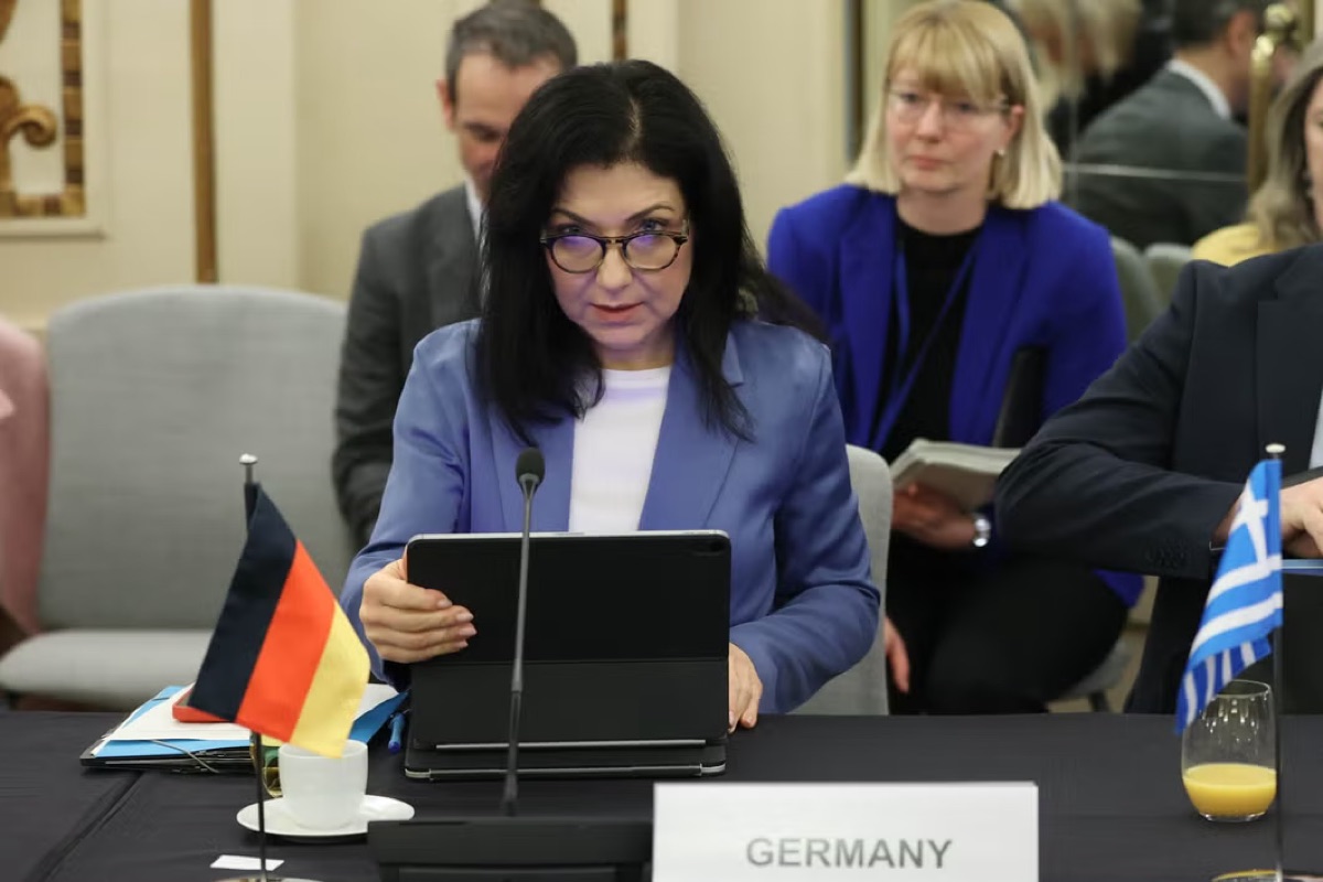 Katherina Reiche seated at an EU ministerial meeting table behind a German flag