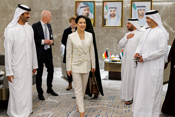 Katherina Reiche walking with Emirati officials in traditional dress