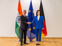Katherina Reiche shaking hands with an Indian minister in front of flags